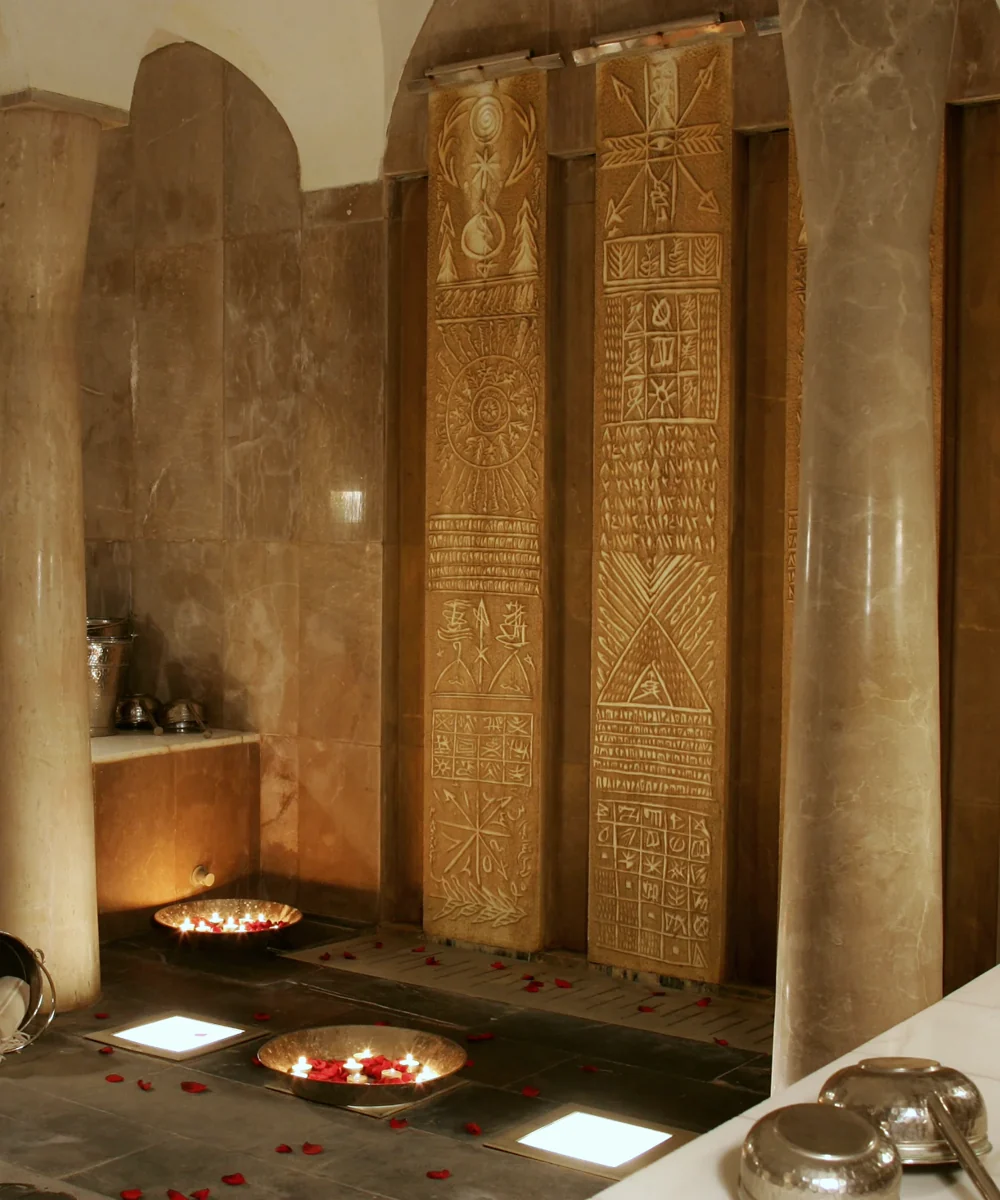Le Spa — the hammam: carved marble stelae, candlelit basins and rose petals